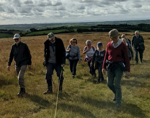 Deep in conversation as the group walk across the moor with distant views behind them