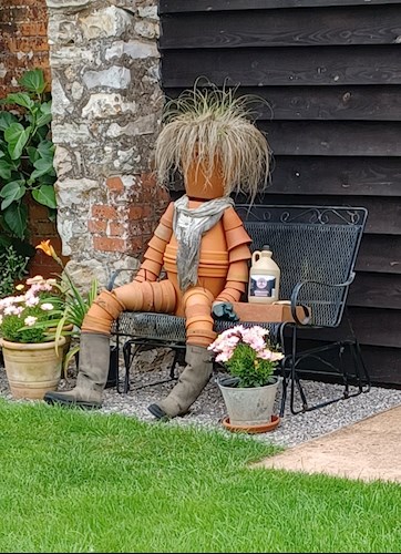 A delightful flowerpot gardener taking a rest on the bench